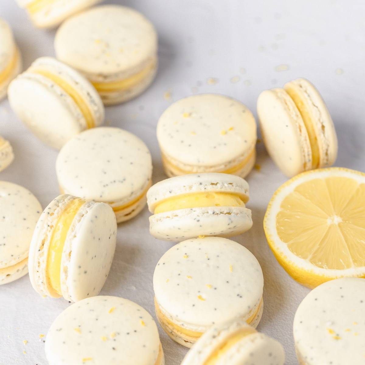 Overhead view of lemon poppy seed macarons with lemon on the side.