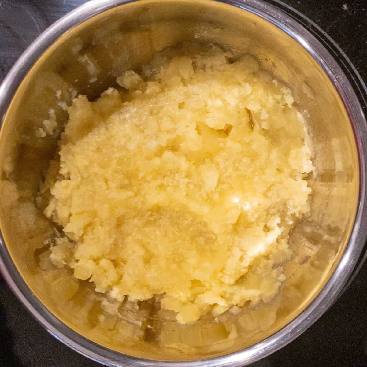 Close up showing potatoes and cauliflower mashed after being boiled