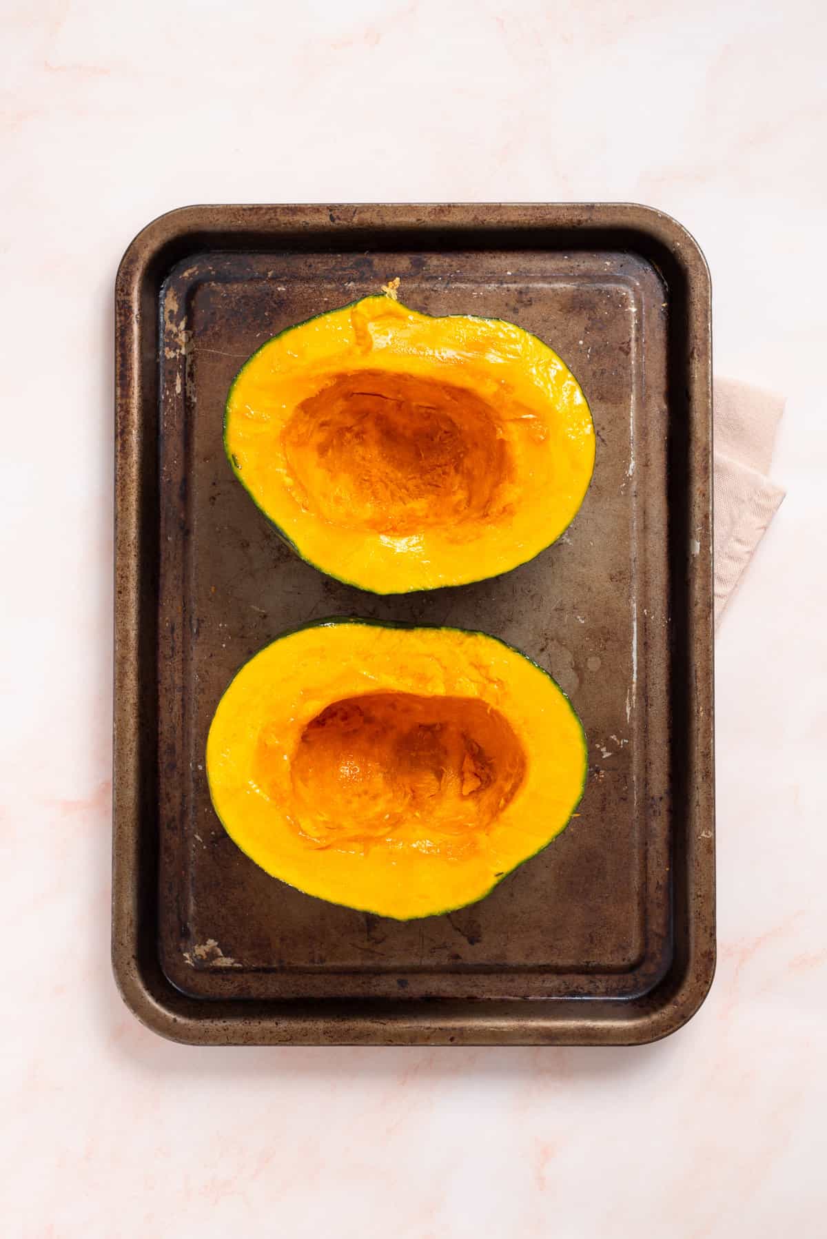 An overhead image of acorn squash on a baking sheet.