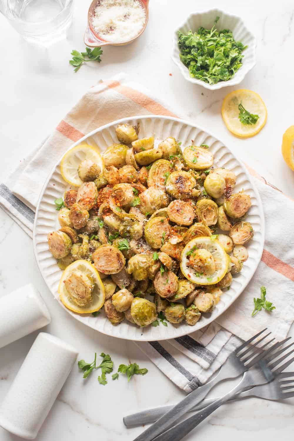 Overhead image of crispy air fryer Brussels sprouts with golden caramelized edges served on a plate.