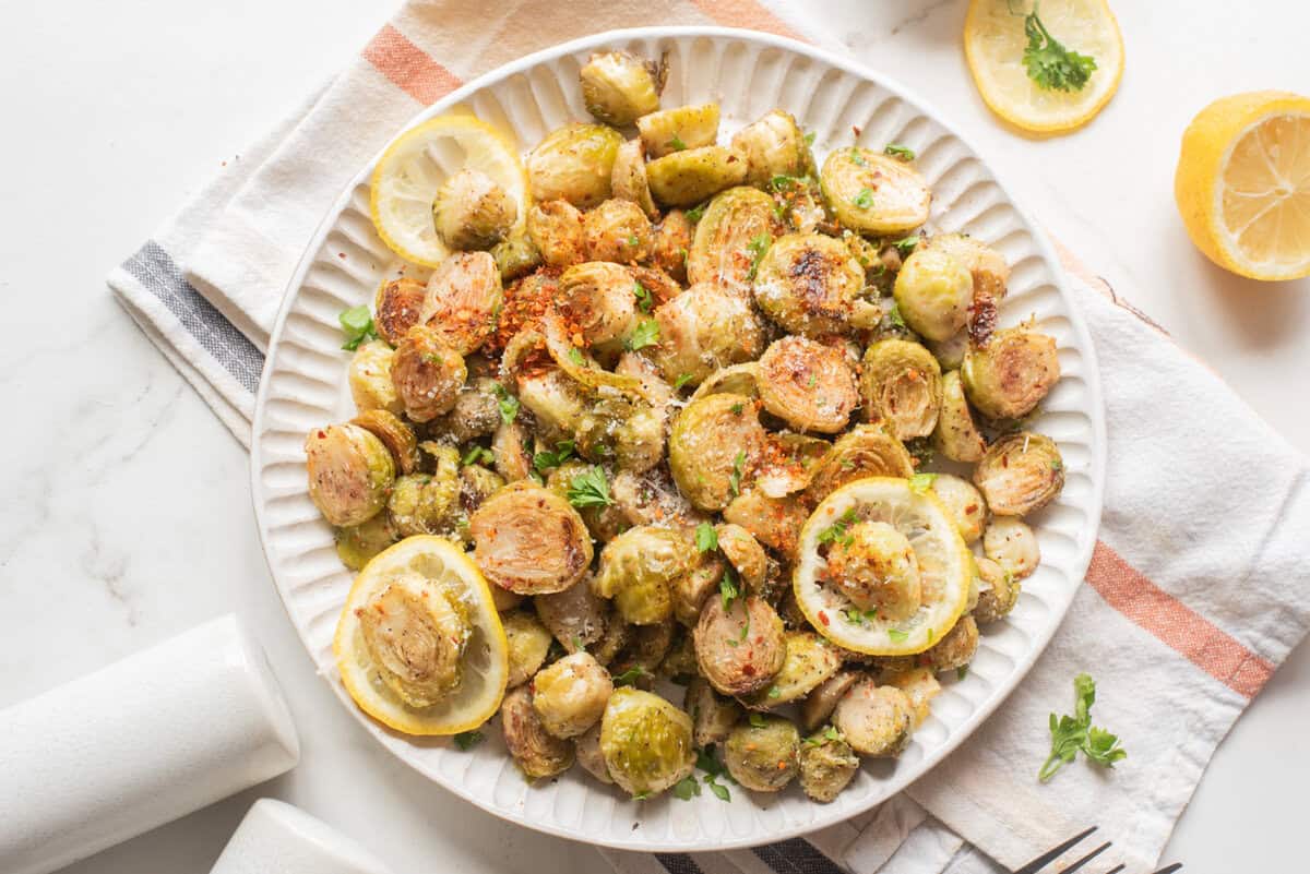 Air fryer Brussels sprouts served with lemon and herb.
