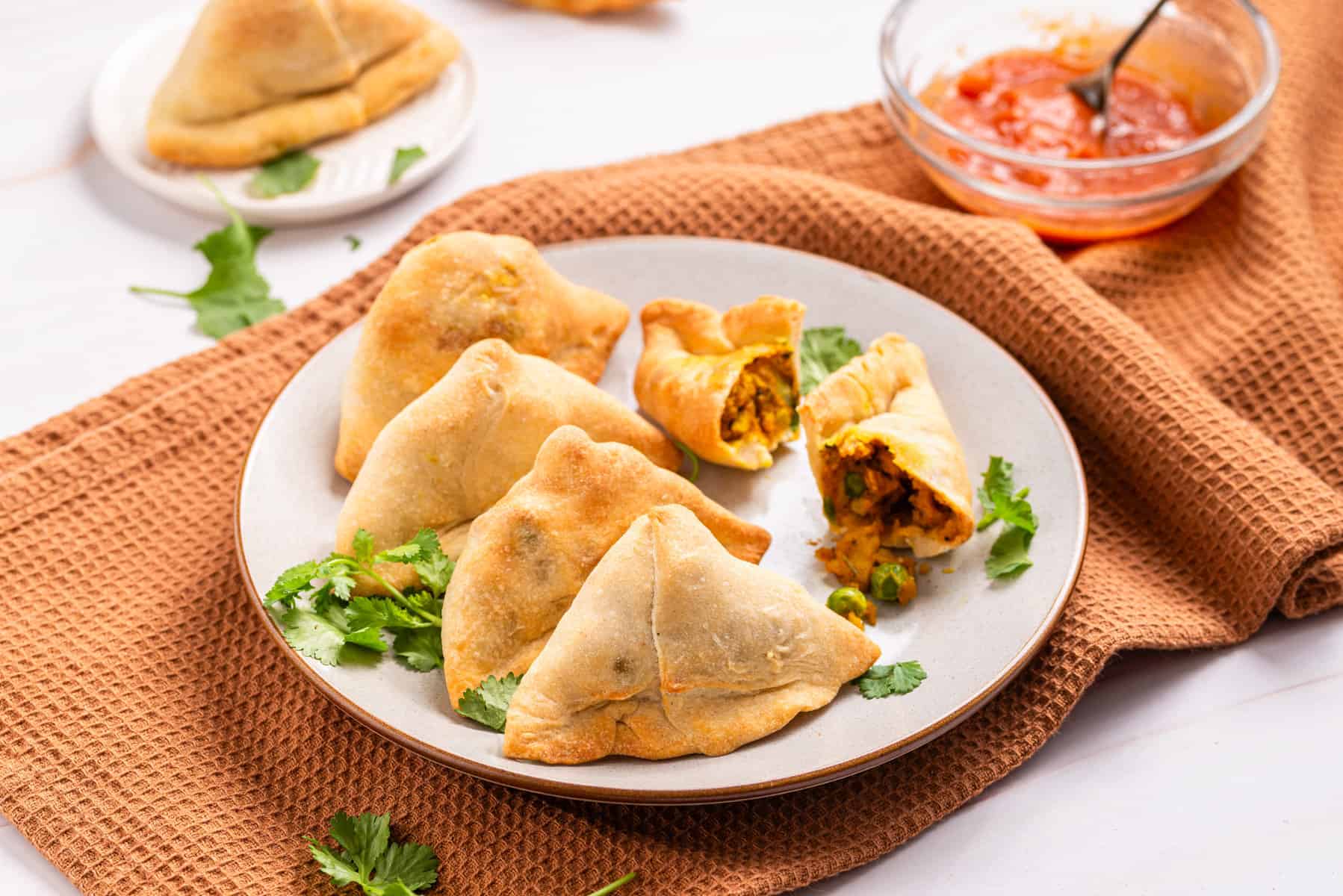 An image of air fryer samosas on a plate that's ready to be served.
