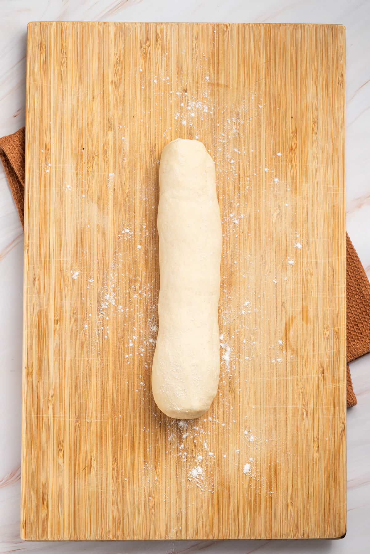 An image of samosa dough formed into a log shape.