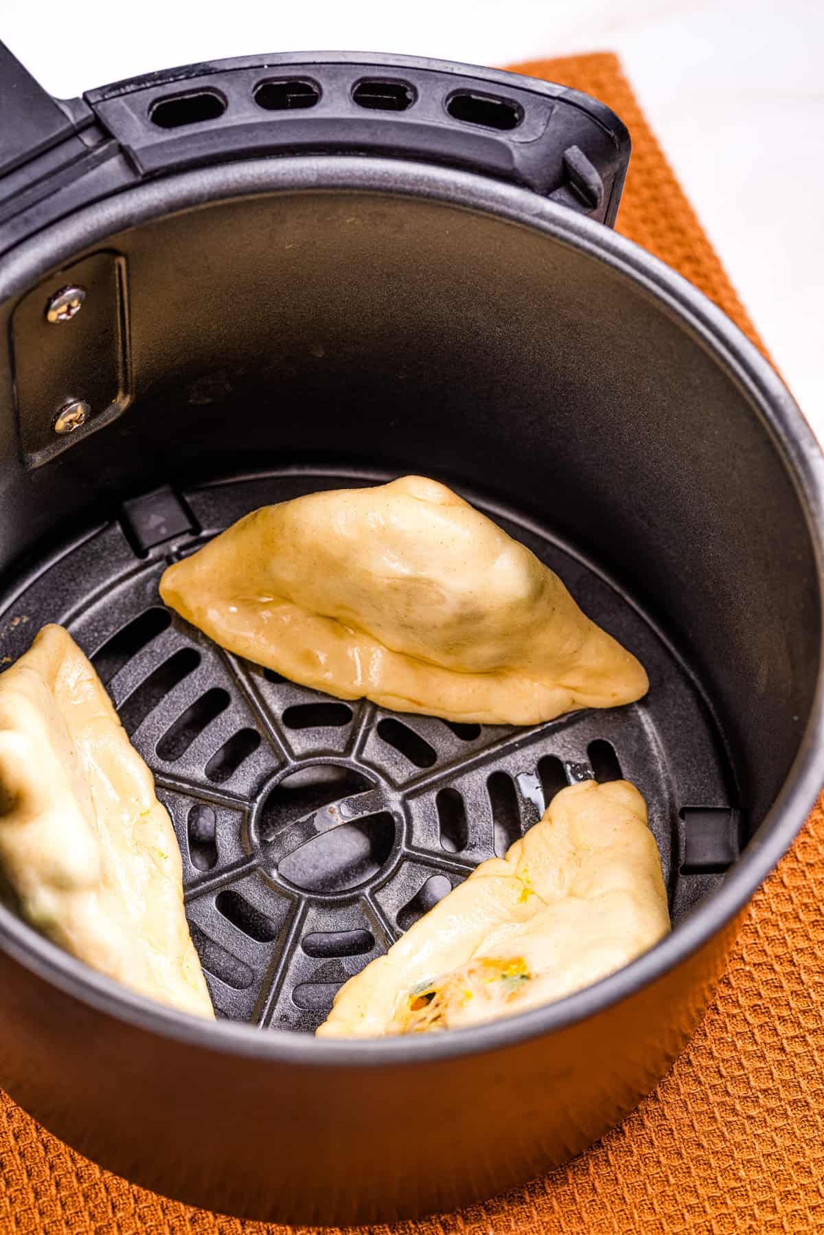An image of samosa being cooked in the air fryer.