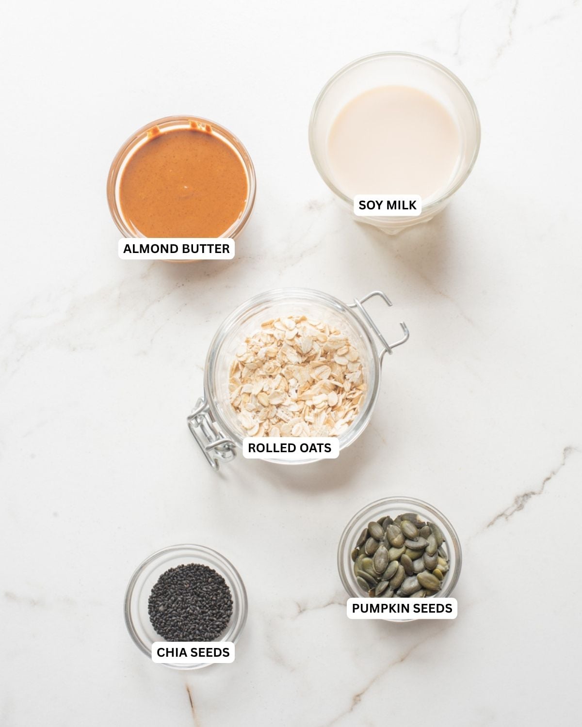Overhead ingredients for almond butter and jam overnight oats.