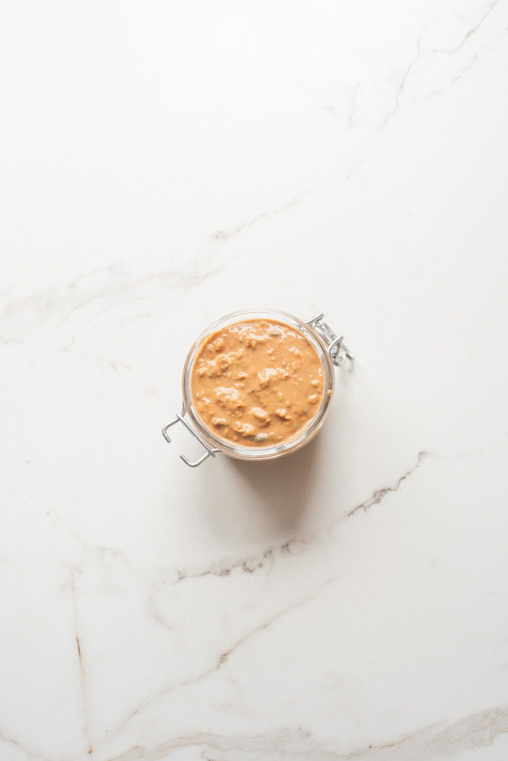 Almond butter and jam overnight oats without toppings in a jar.