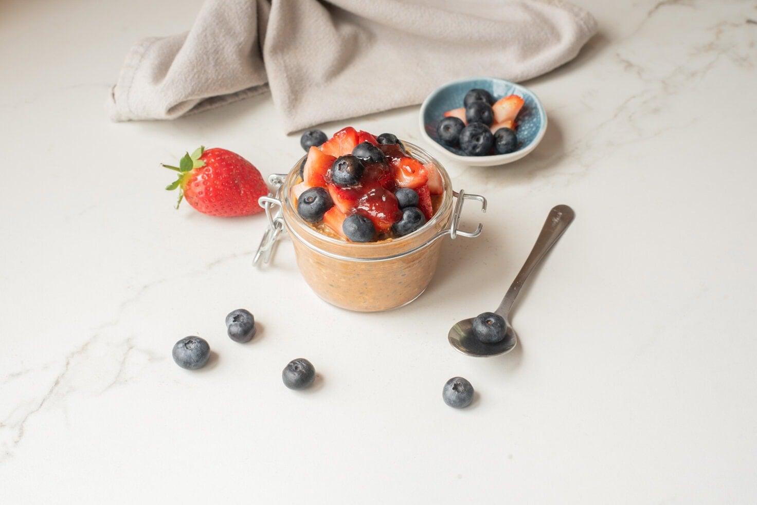 Almond butter and jam overnight oats with toppings.