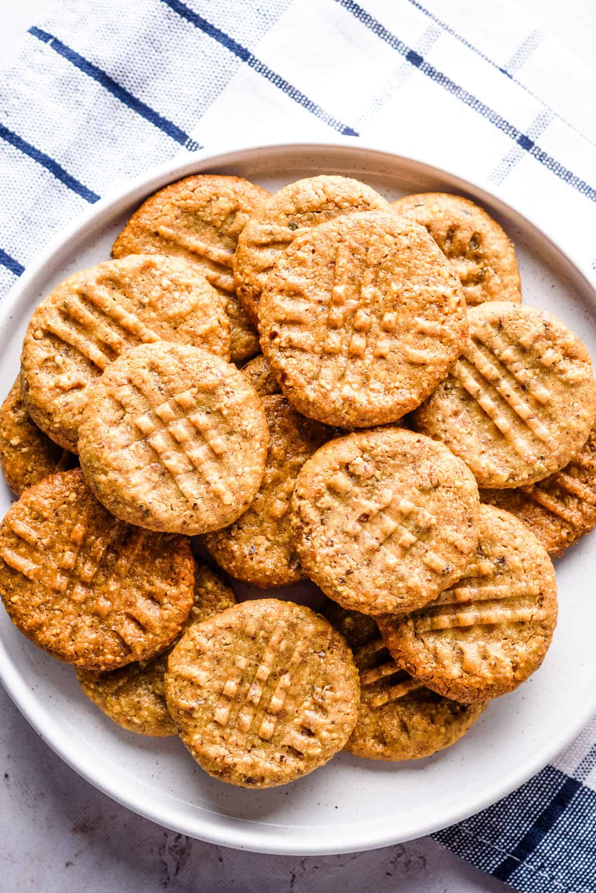 Overhead view of almond flour peanut butter cookies on a white plate. 