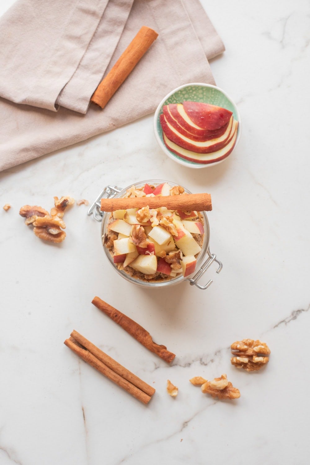 Overhead image of apple pie chia overnight oats with toppings in a jar.