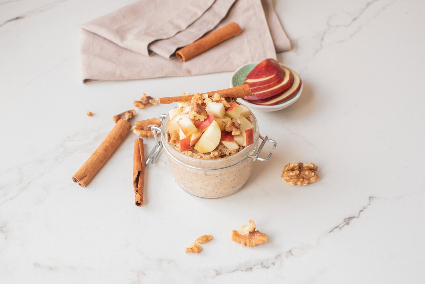Apple pie chia overnight oats with toppings in a jar.