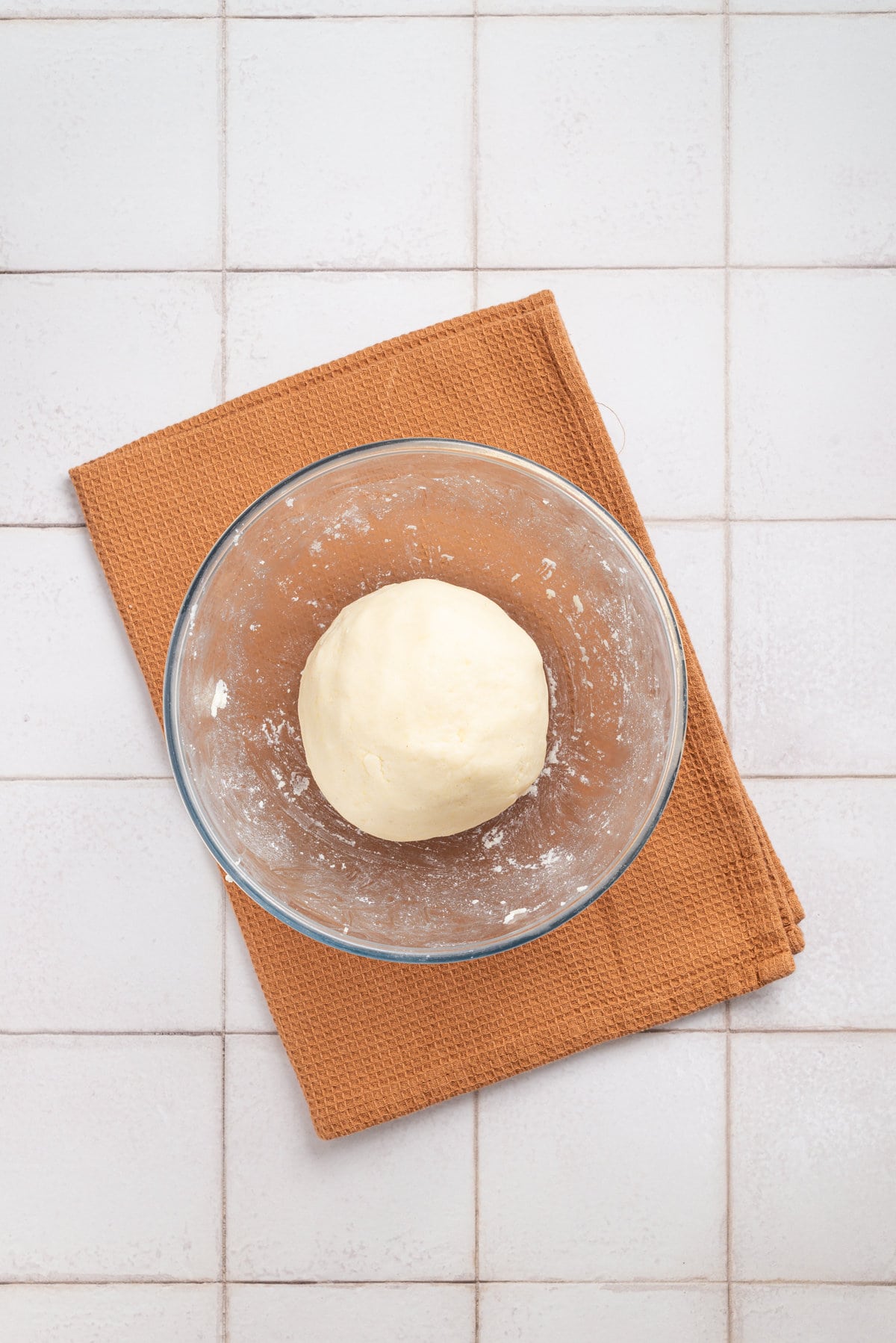 An overhead image of dough kneaded into a big ball.