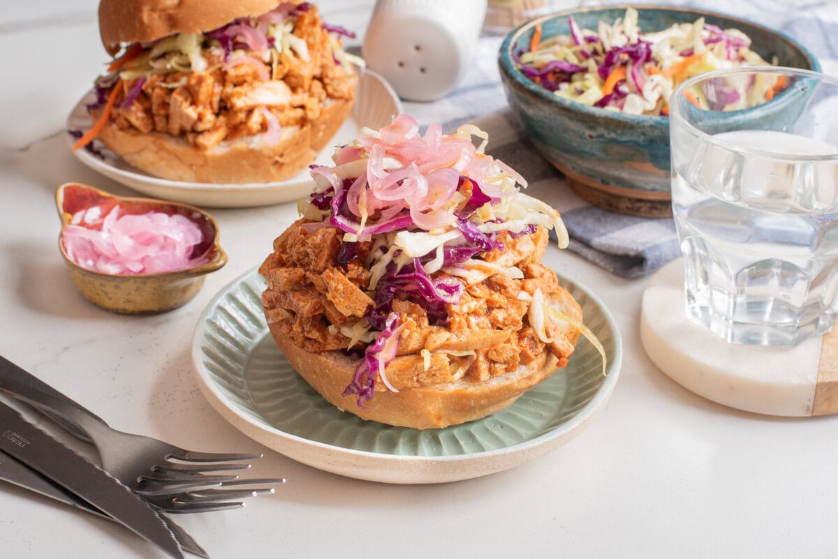A close up image of BBQ tofu sandwich on a plate.