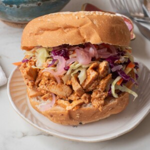 A close up image of BBQ tofu sandwich on a plate.