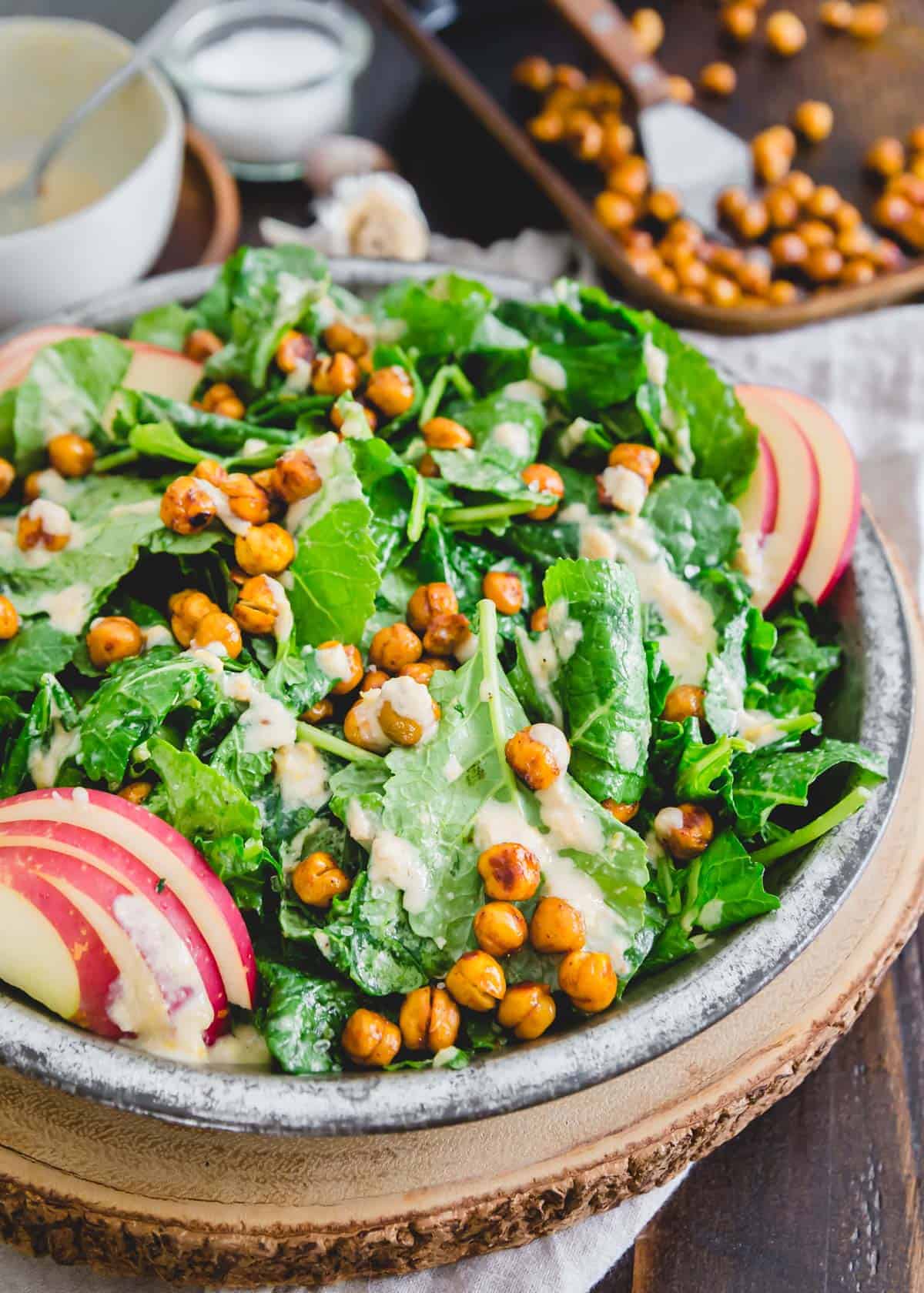 A close-up view of a bowl full of kale apple salad with BBQ chickpeas.