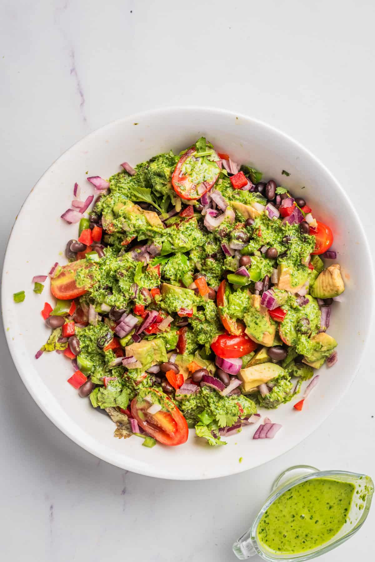 An overhead image of black bean salad with cilantro lime dressing on top in a bowl.