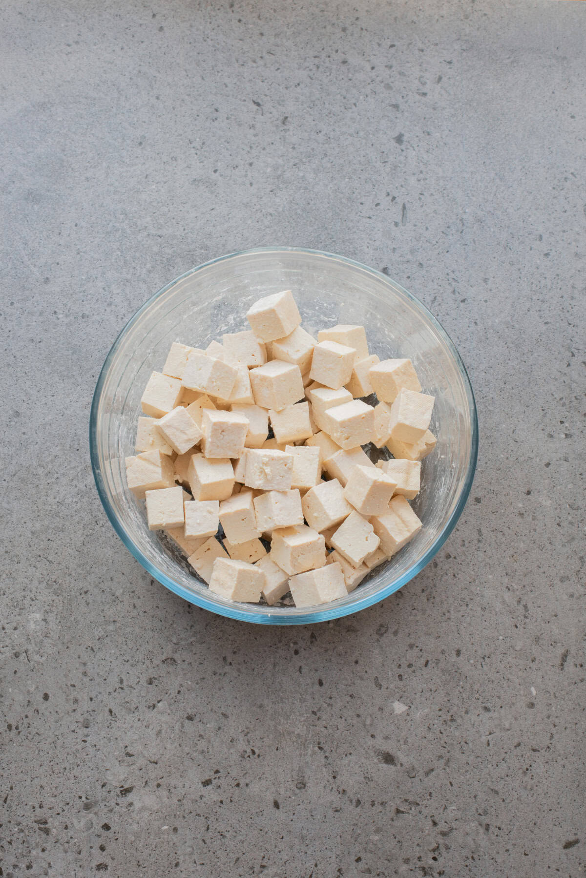 An overhead image of coating the tofu with cornstarch.