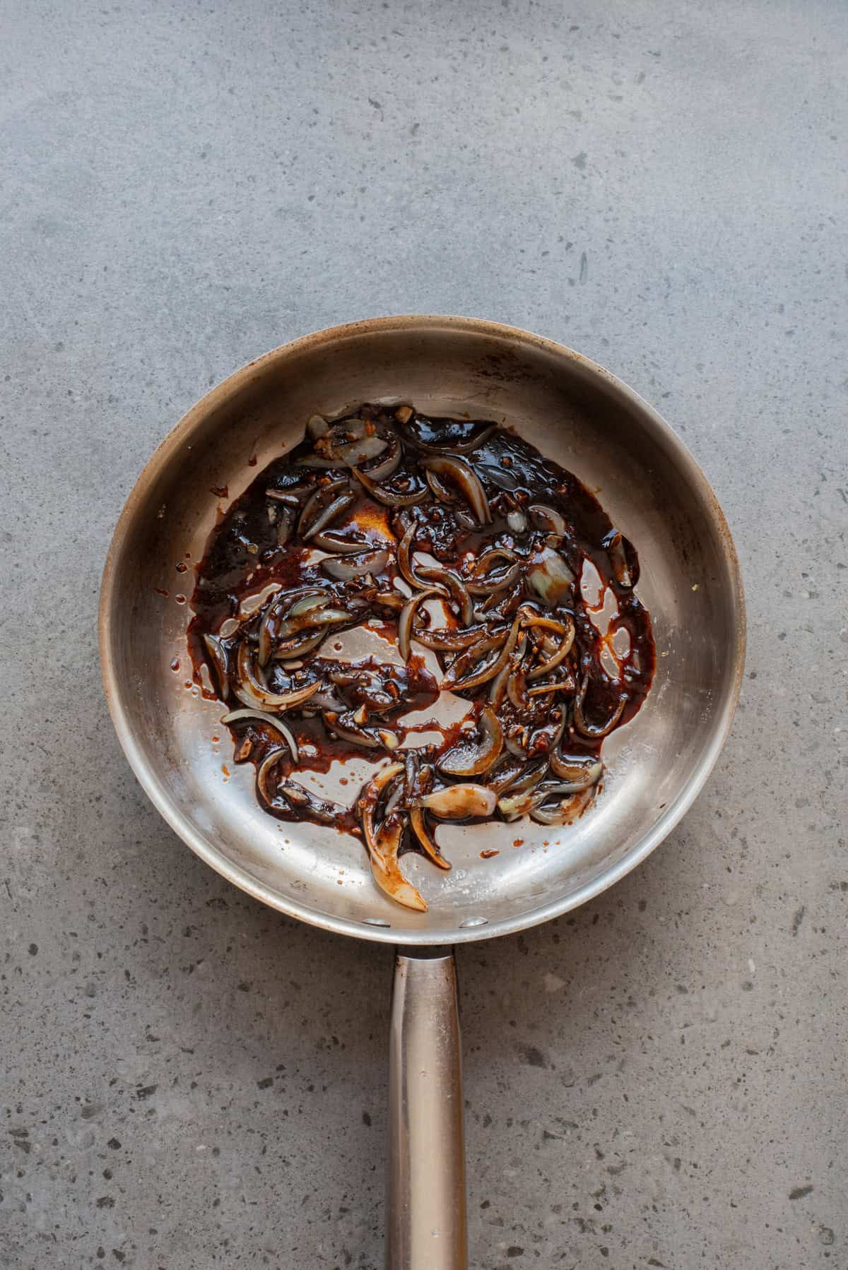 An overhead image of adding the sauce mixture into the skillet.