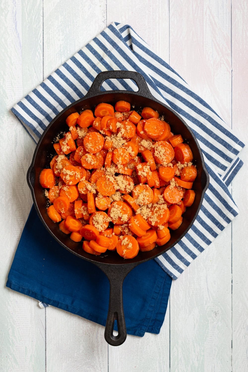 Brown sugar glazed added to the carrots in a skillet.