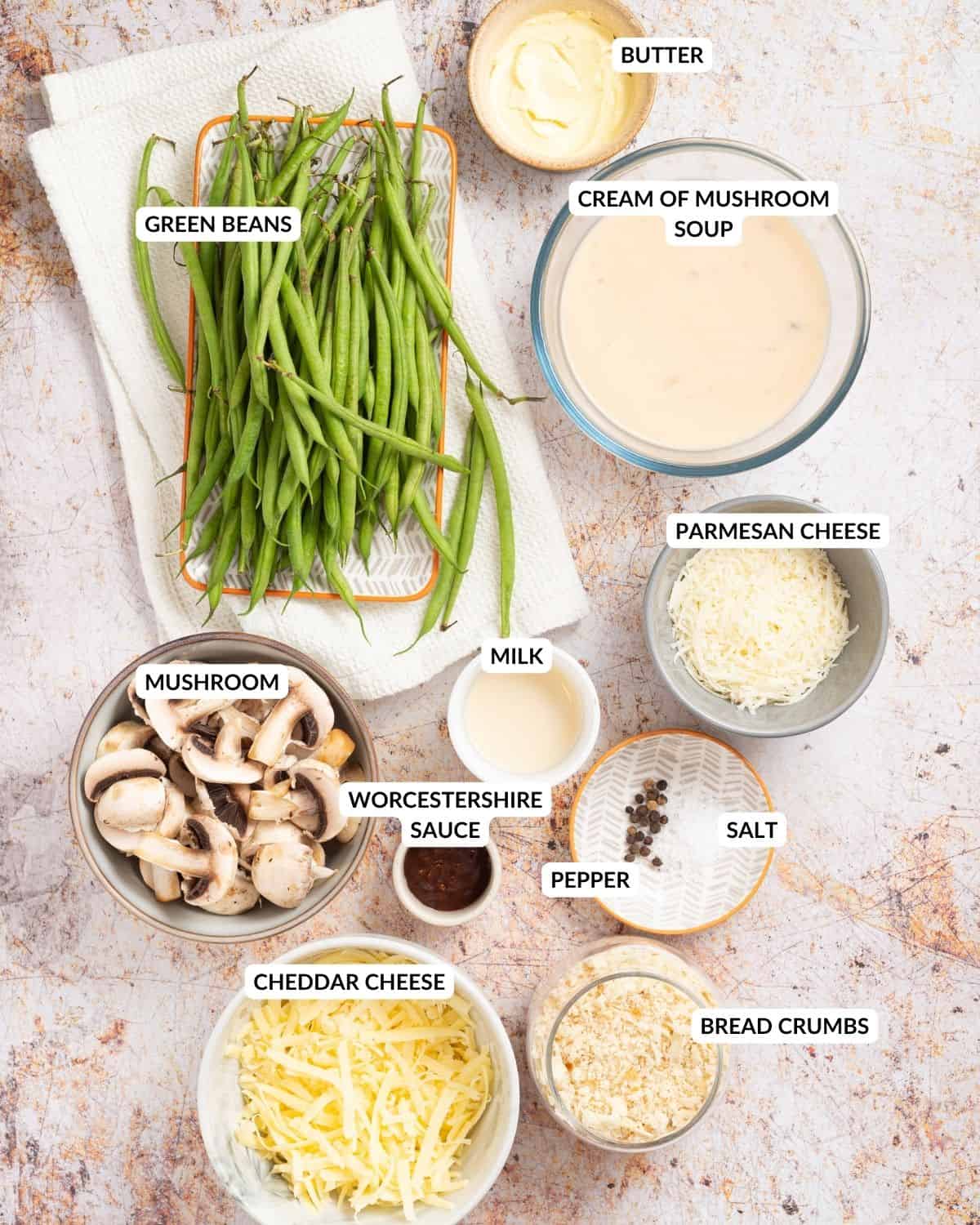 An overhead image of all the ingredients of cheesy green bean casserole in separate containers with labels.