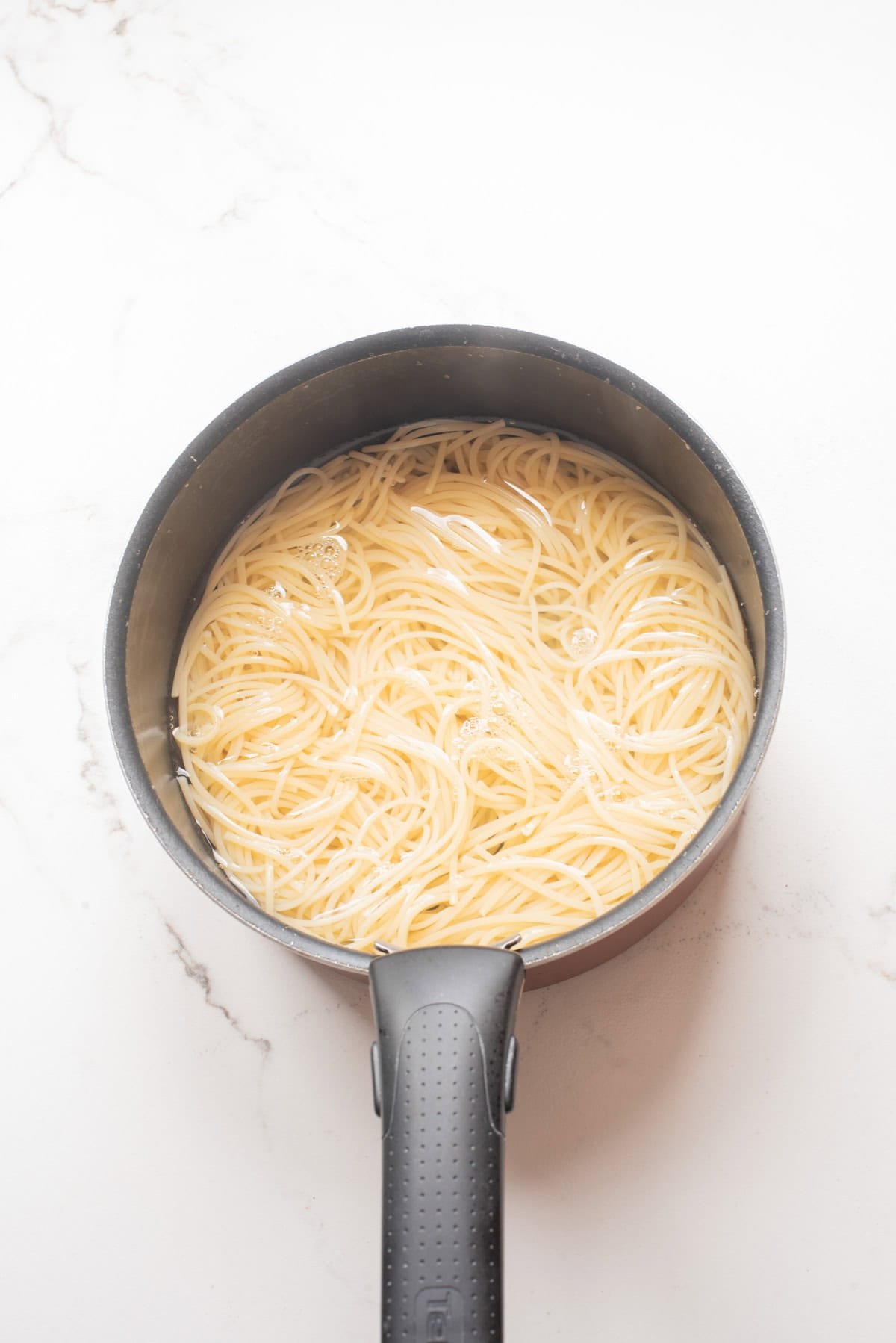 An overhead image of boiling pasta in a pot.