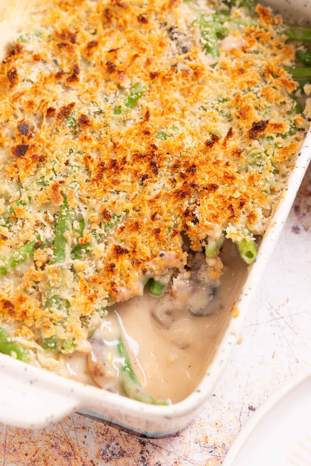 An overhead image of green bean casserole with a serving missing frmo the casserole dish.