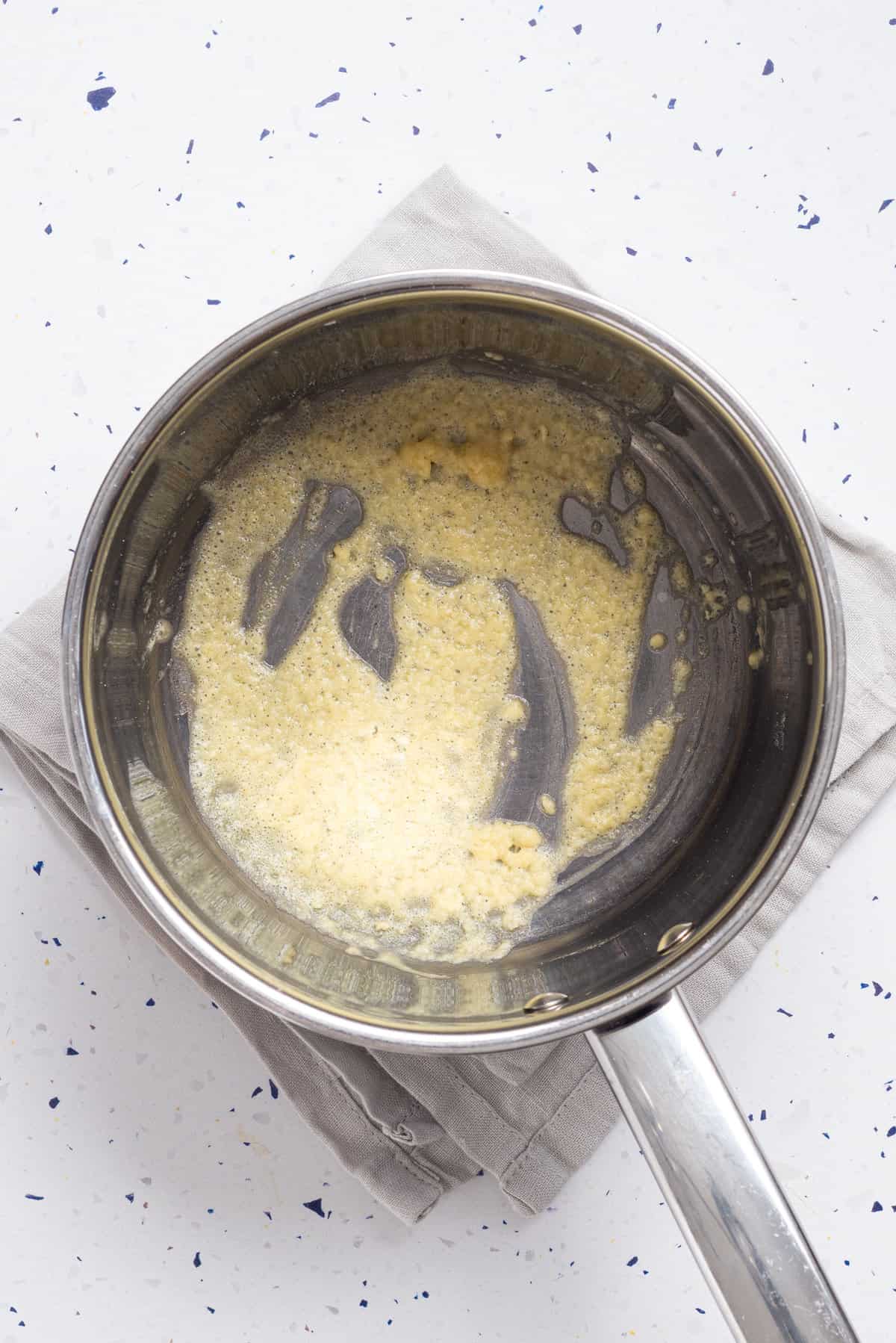 An overhead image of butter and flour, melted and mixed together in a pot.