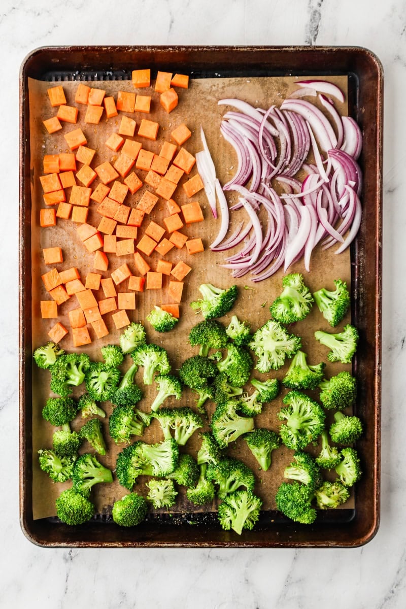 An overhead image of sliced vegetables on a baking sheet.