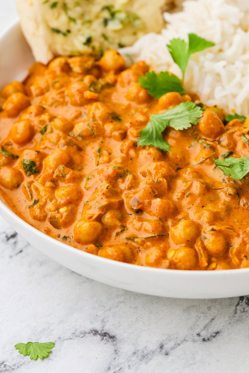 A close up image of chickpea tikka masala served in a bowl with rice.