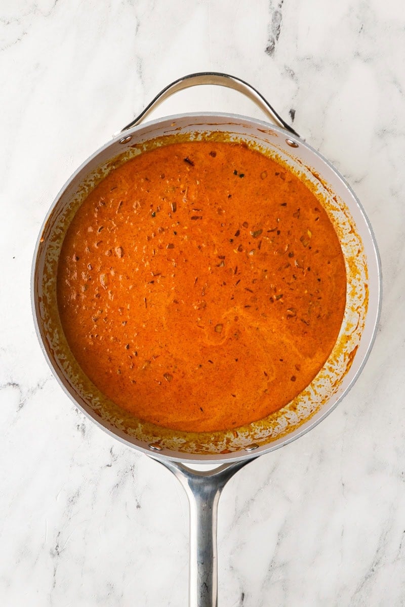 An overhead image of adding creamt o the mixture.