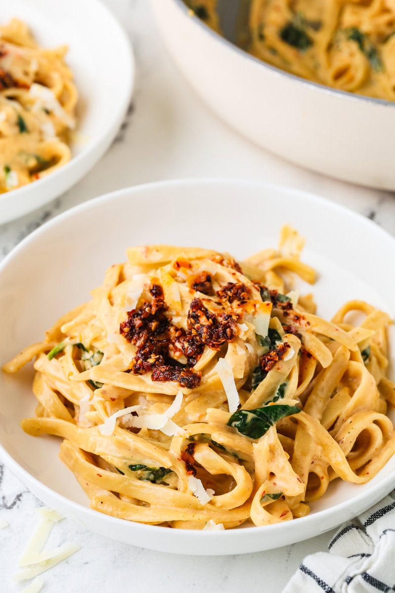 A close up image of chili crisp fettuccine alfredo in a bowl.