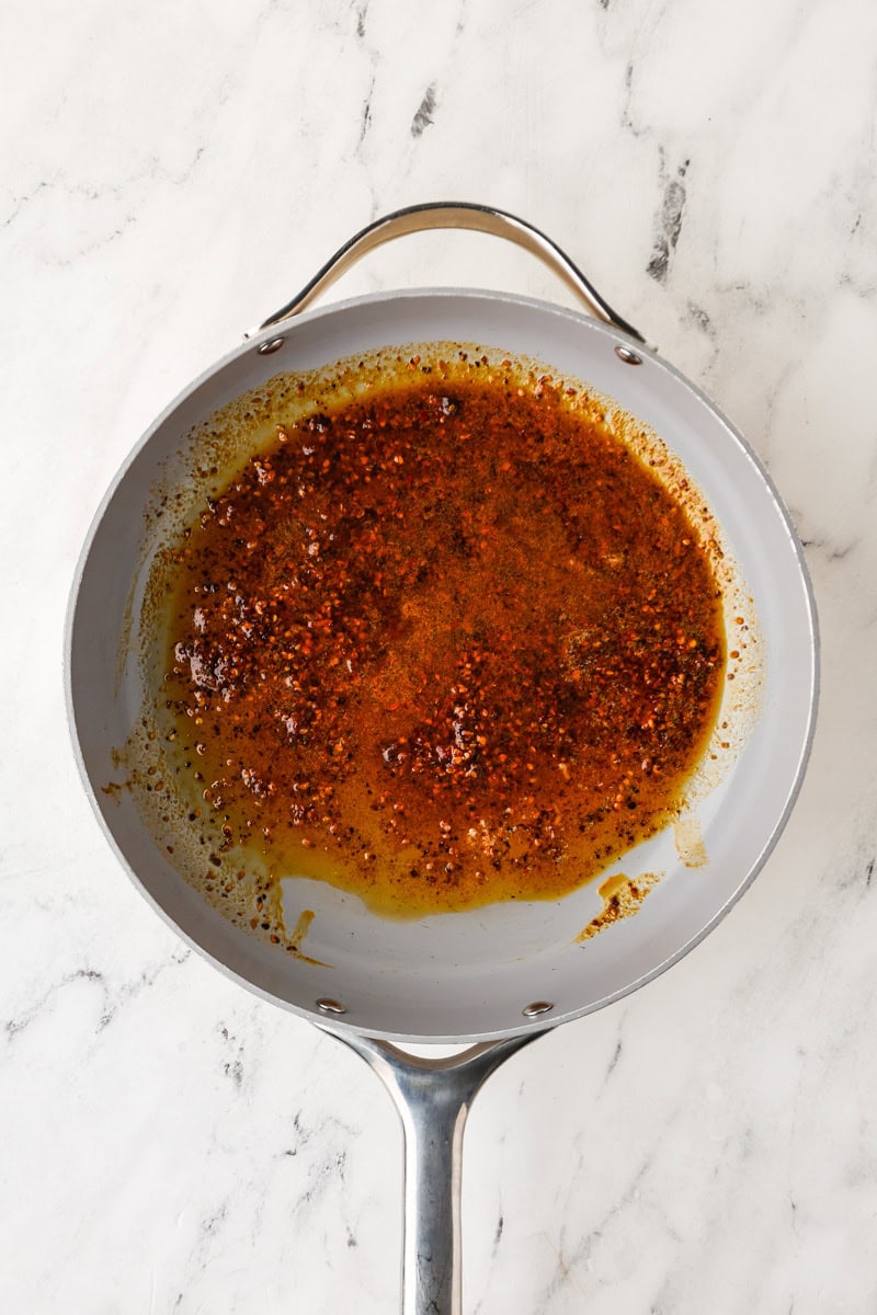 An overhead image of blooming the chili crisp in a skillet.