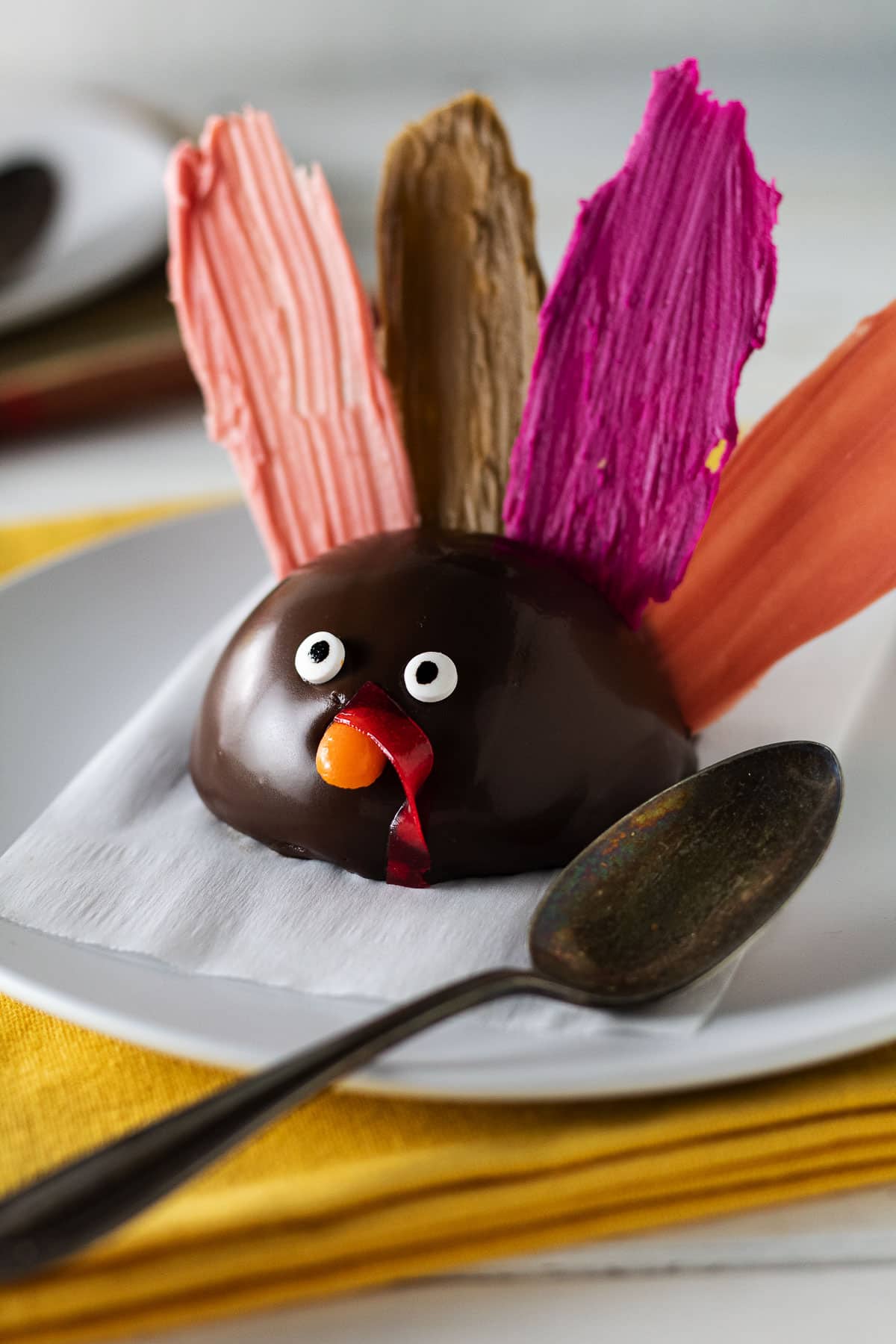 Close up of pumpkin mousse shaped like a turkey with multicolored feather wafers.