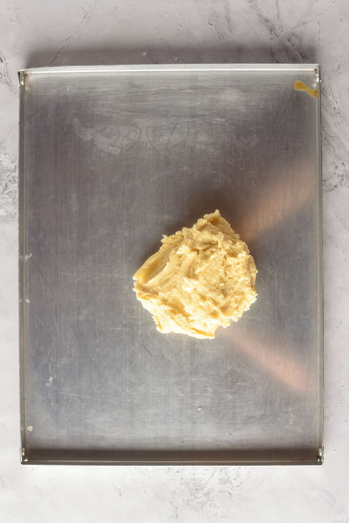 Overhead view of dough on a flat surface, before being rolled out.