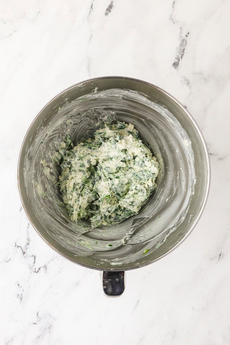 Spinach dip ingredients mixed together in a bowl.