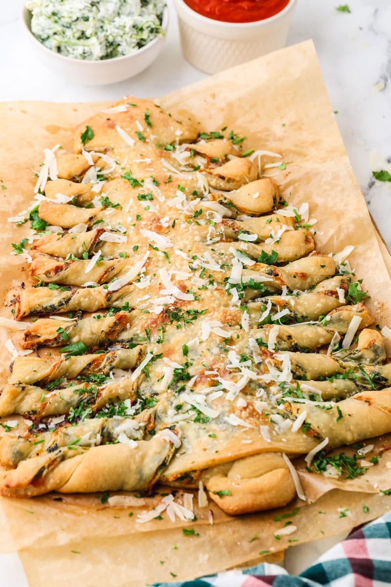 Baked Christmas tree spinach dip breadsticks topped with Parmesan and parsley.