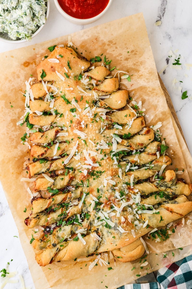 Christmas tree spinach dip breadsticks topped with Parmesan and parsley.