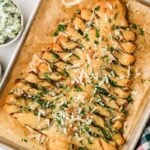 Christmas tree spinach dip breadsticks served with spinach dip and marinara on a baking sheet.