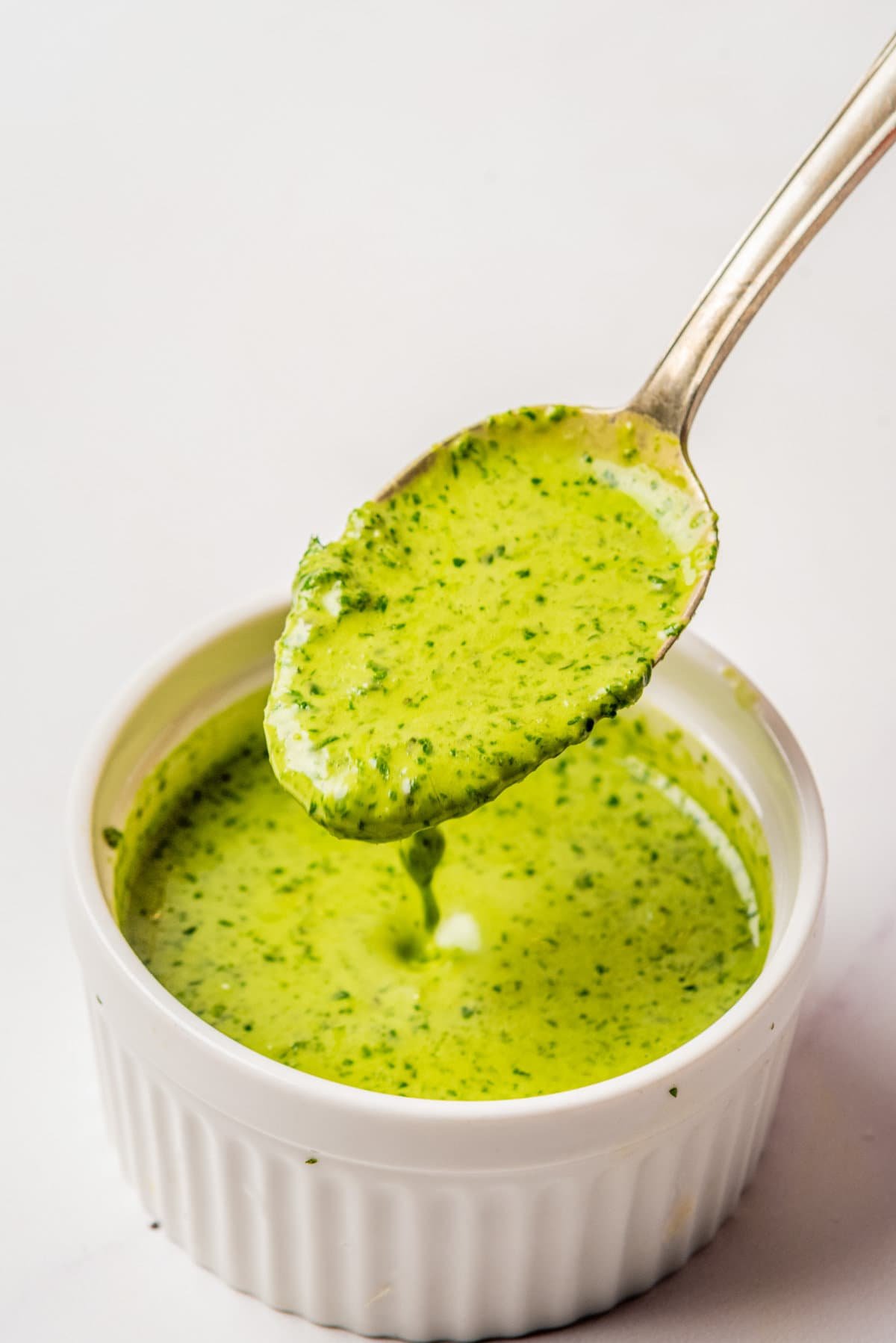 An image of a spoon scooping up a spoonful of cilantro lime dressing.