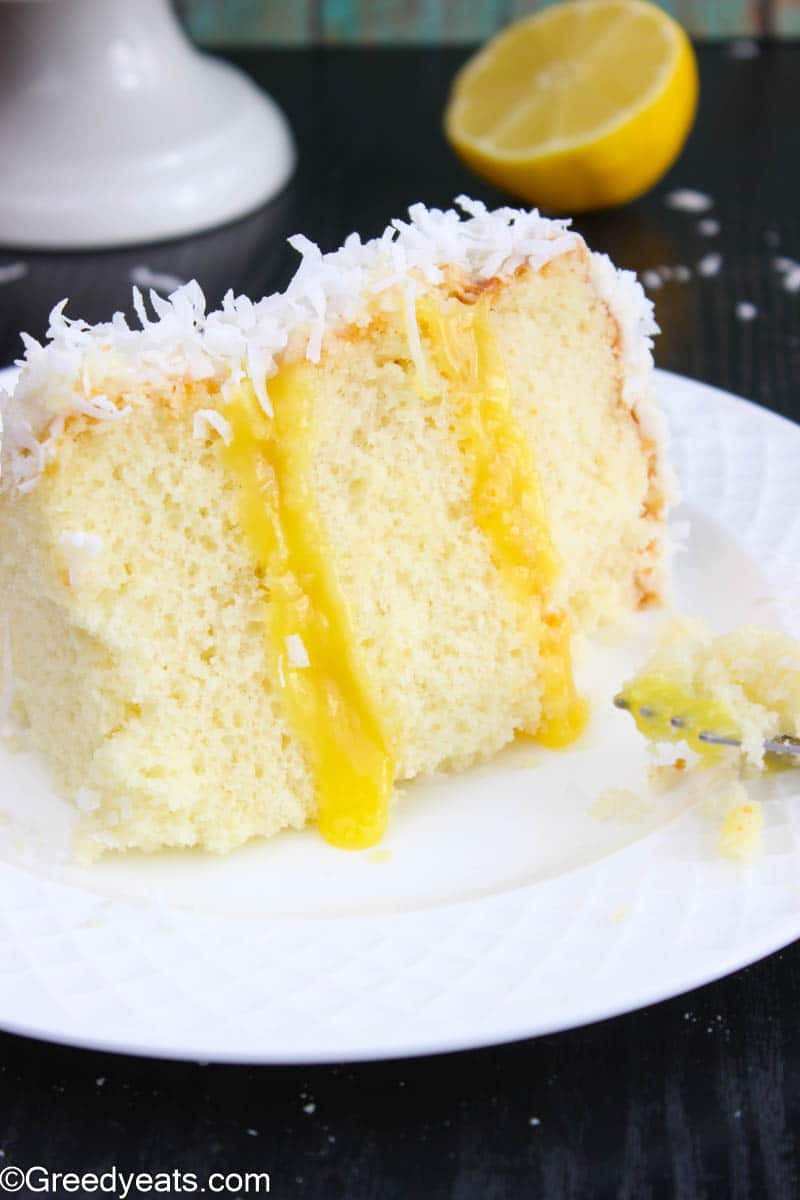 A close-up view of lemon coconut cake placed on a white plate.
