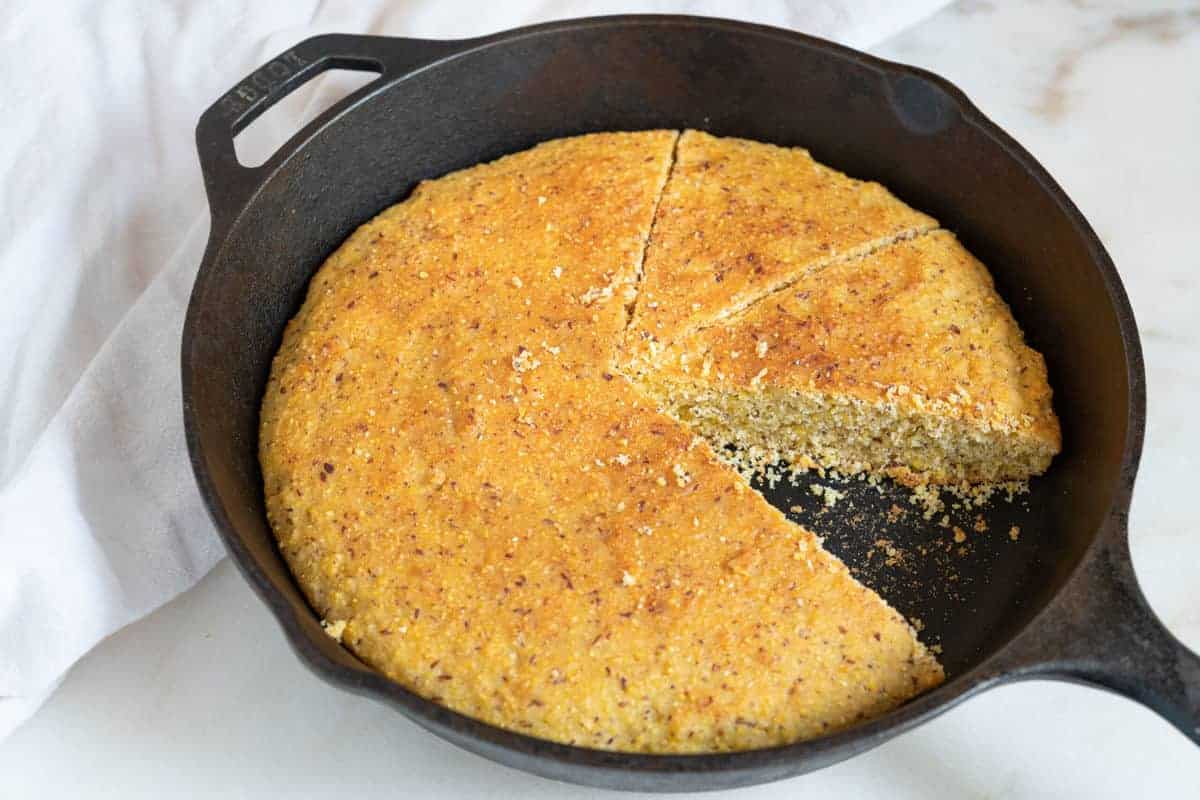 An overhead view of skillet cornbread with one slice taken out.