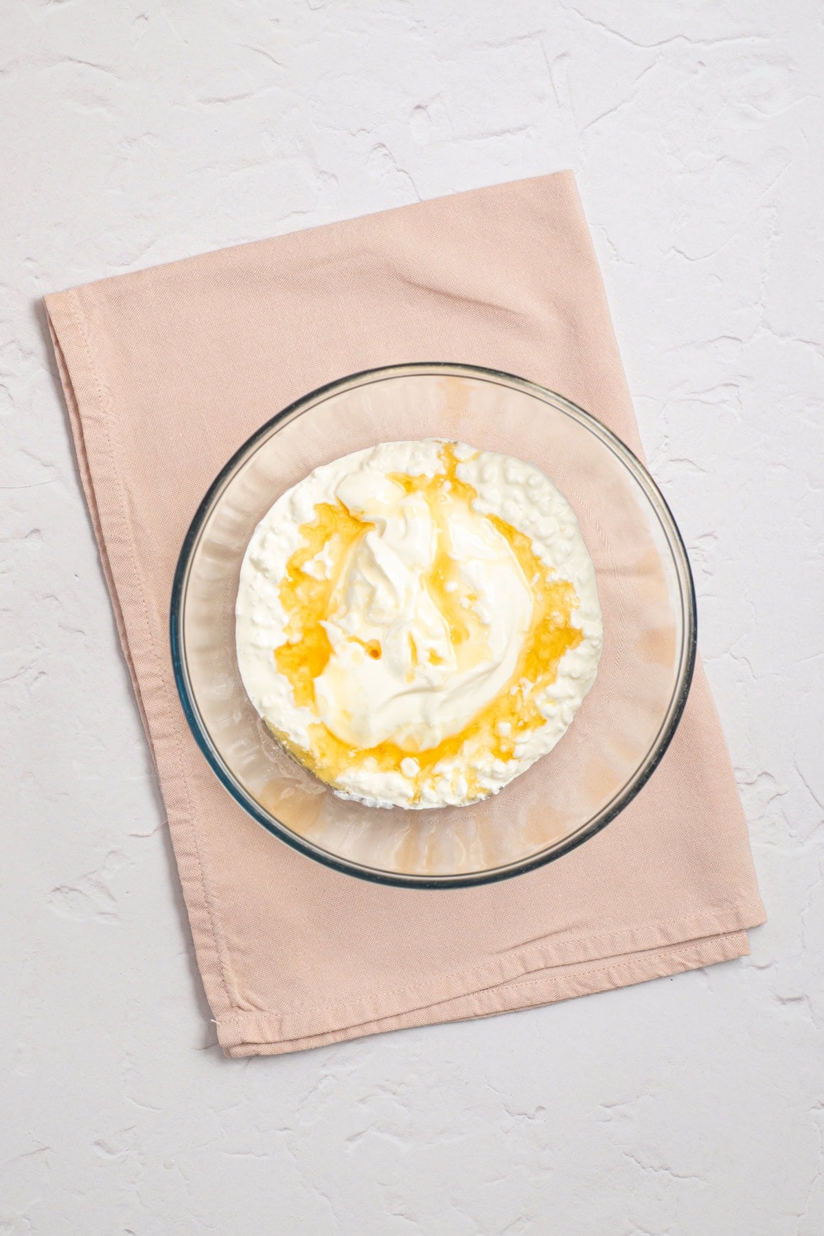 Blended cottage cheese, Greek yogurt, honey, and vanilla mixture in a glass mixing bowl.