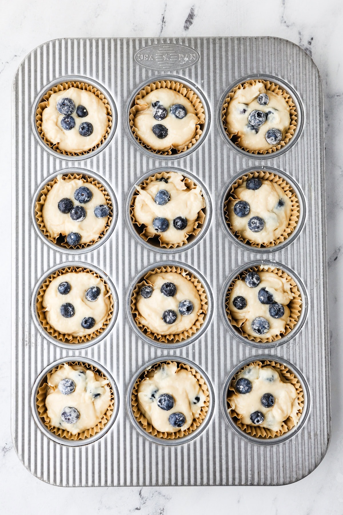An overhead image of transferring the mixture in a muffin tin.