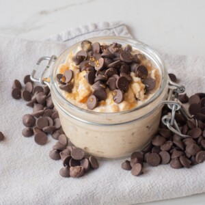 Close-up of cottage cheese cookie dough overnight oats topped with mini chocolate chips in a jar.