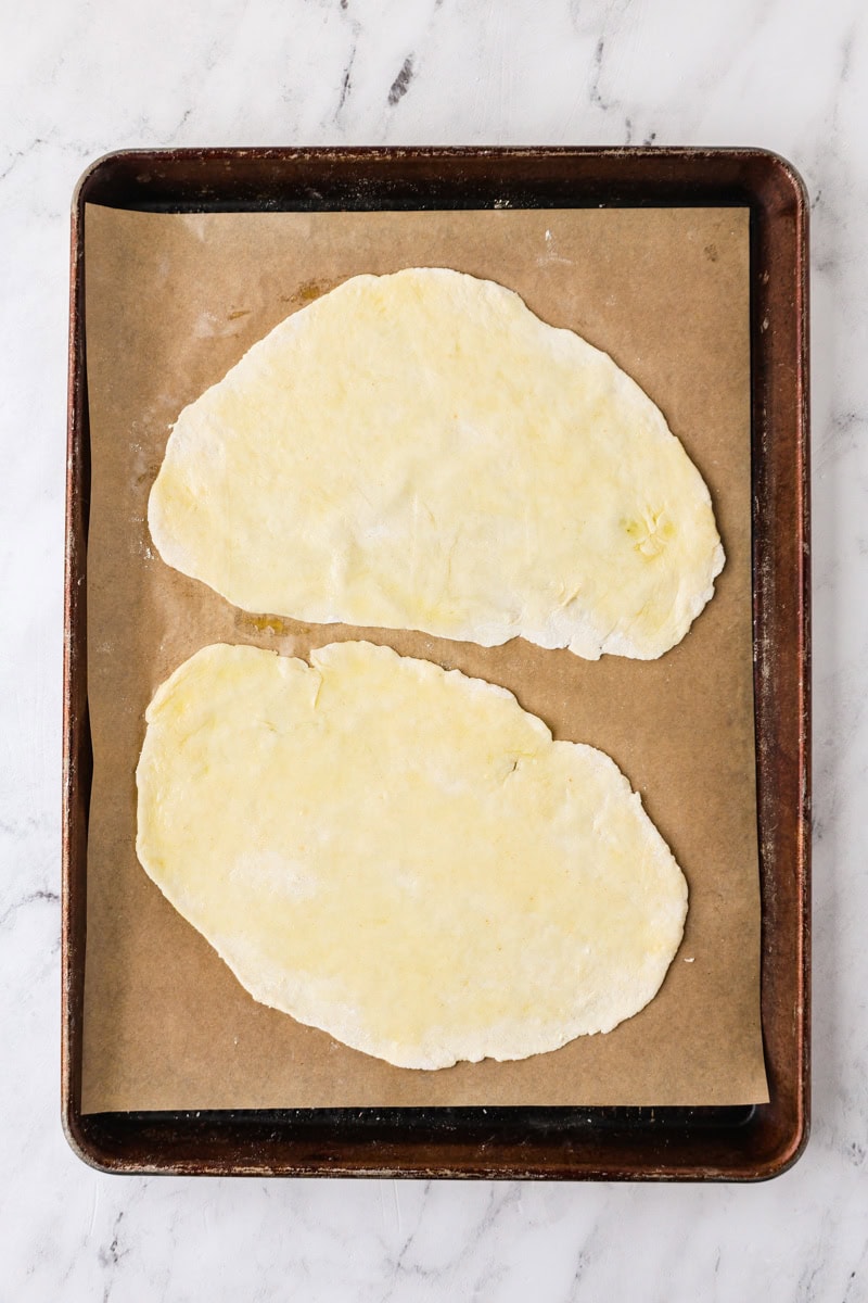 An overhead image of the flatbread dough on a baking sheet.