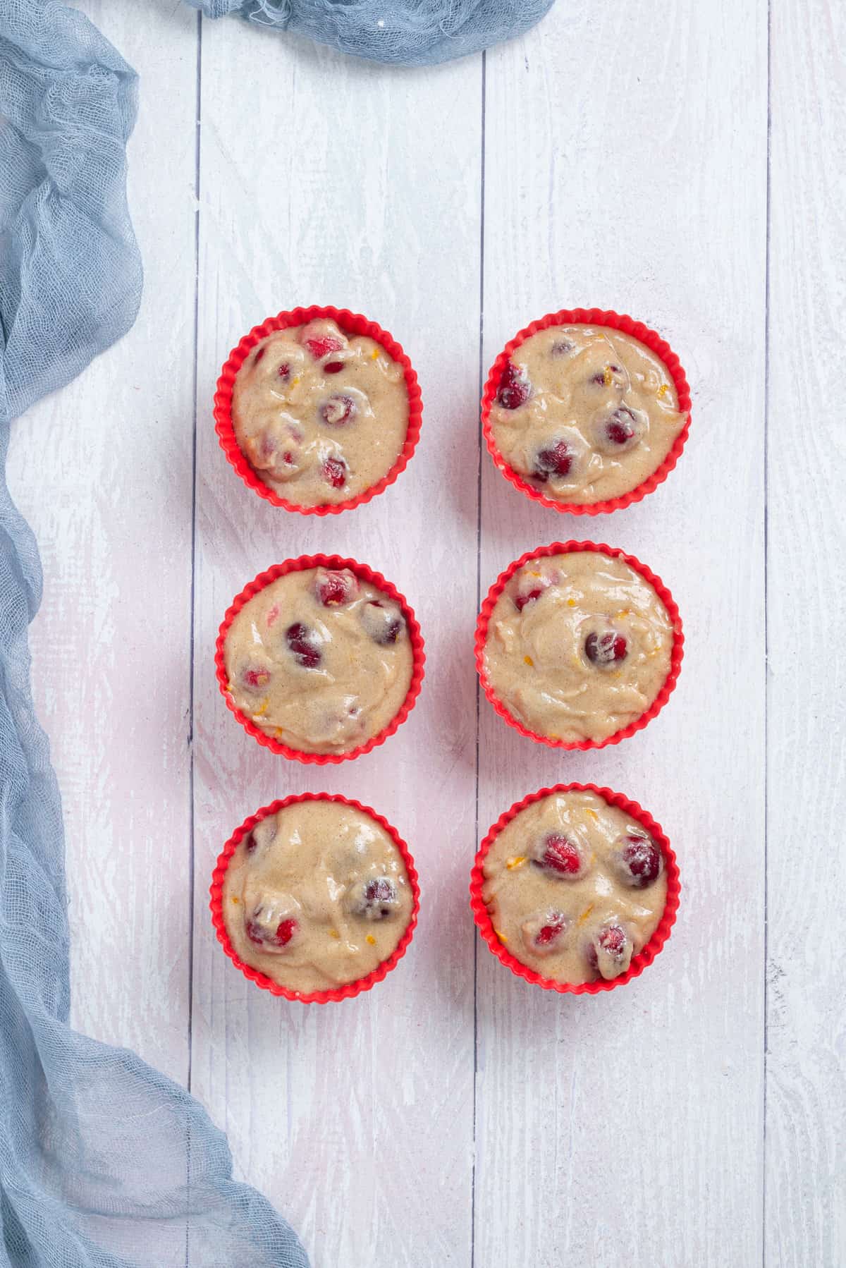 An overhead image of the muffin batter in muffin tins arranged side by side.