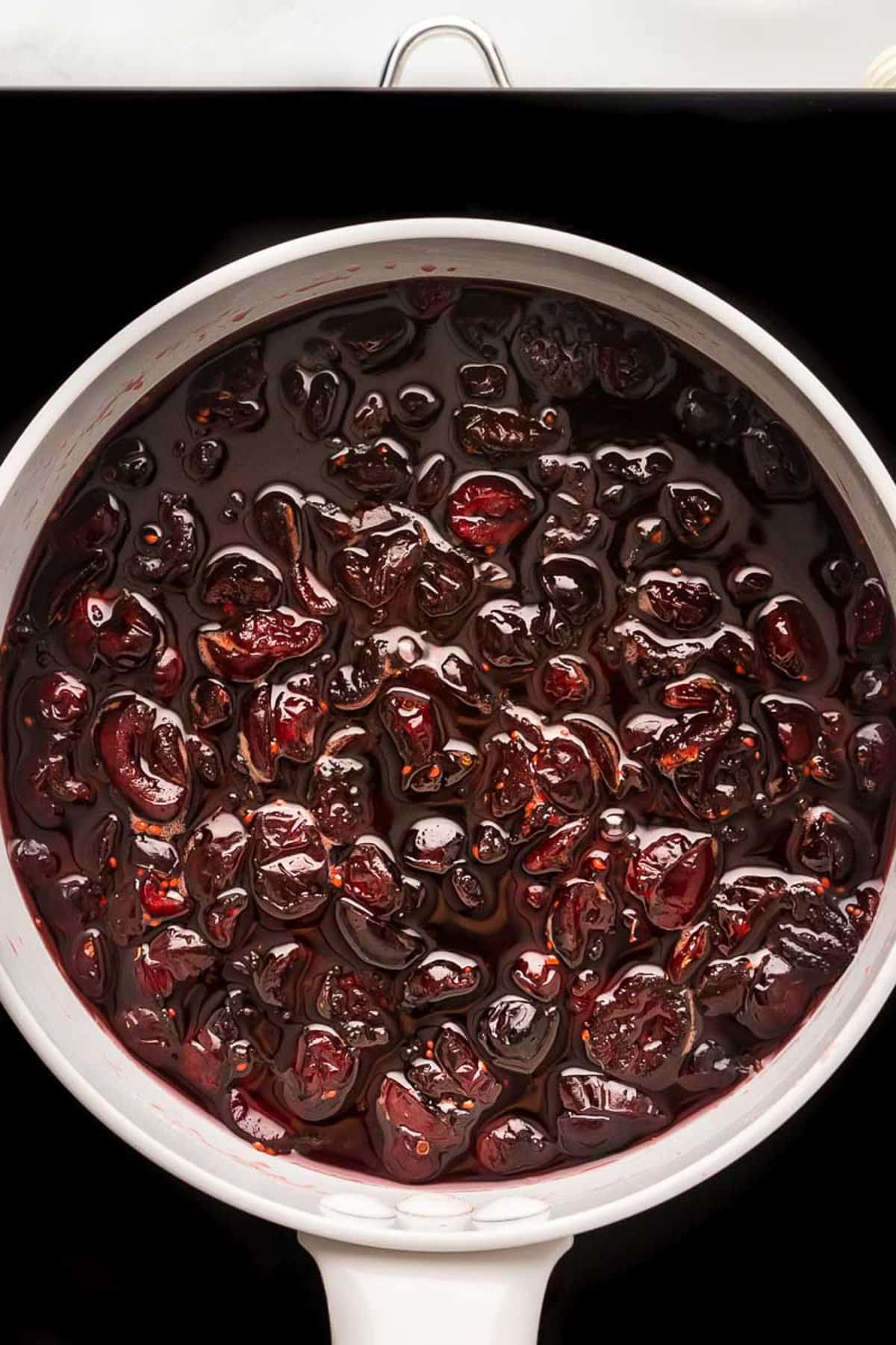Overhead view of cranberry sauce almost formed in the pot.