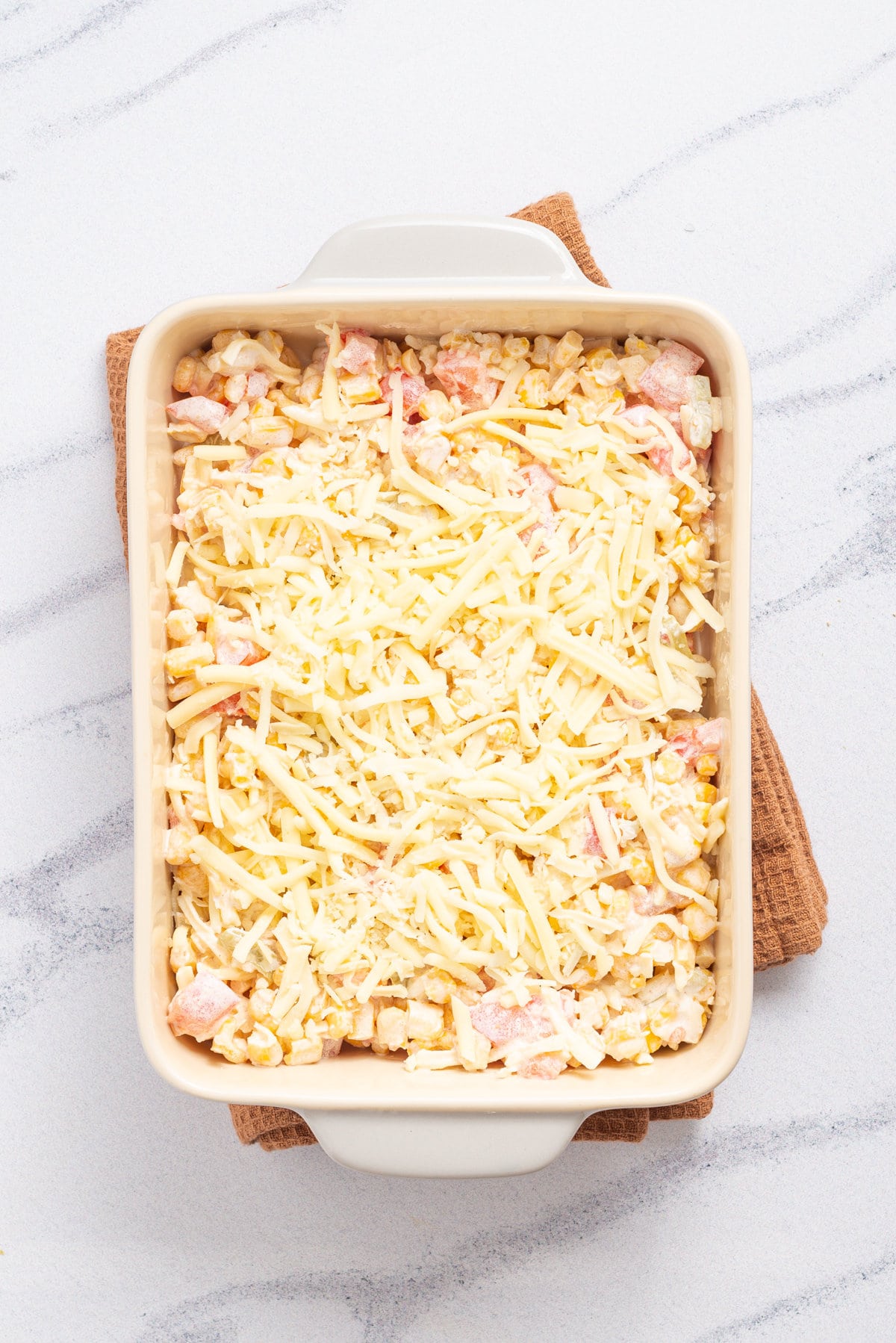 An overhead image of the top layer full of cheese in a baking dish.