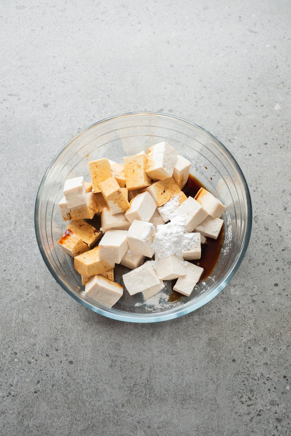 An overhead image of mixing the tofu with cornstarch and soy sauce.