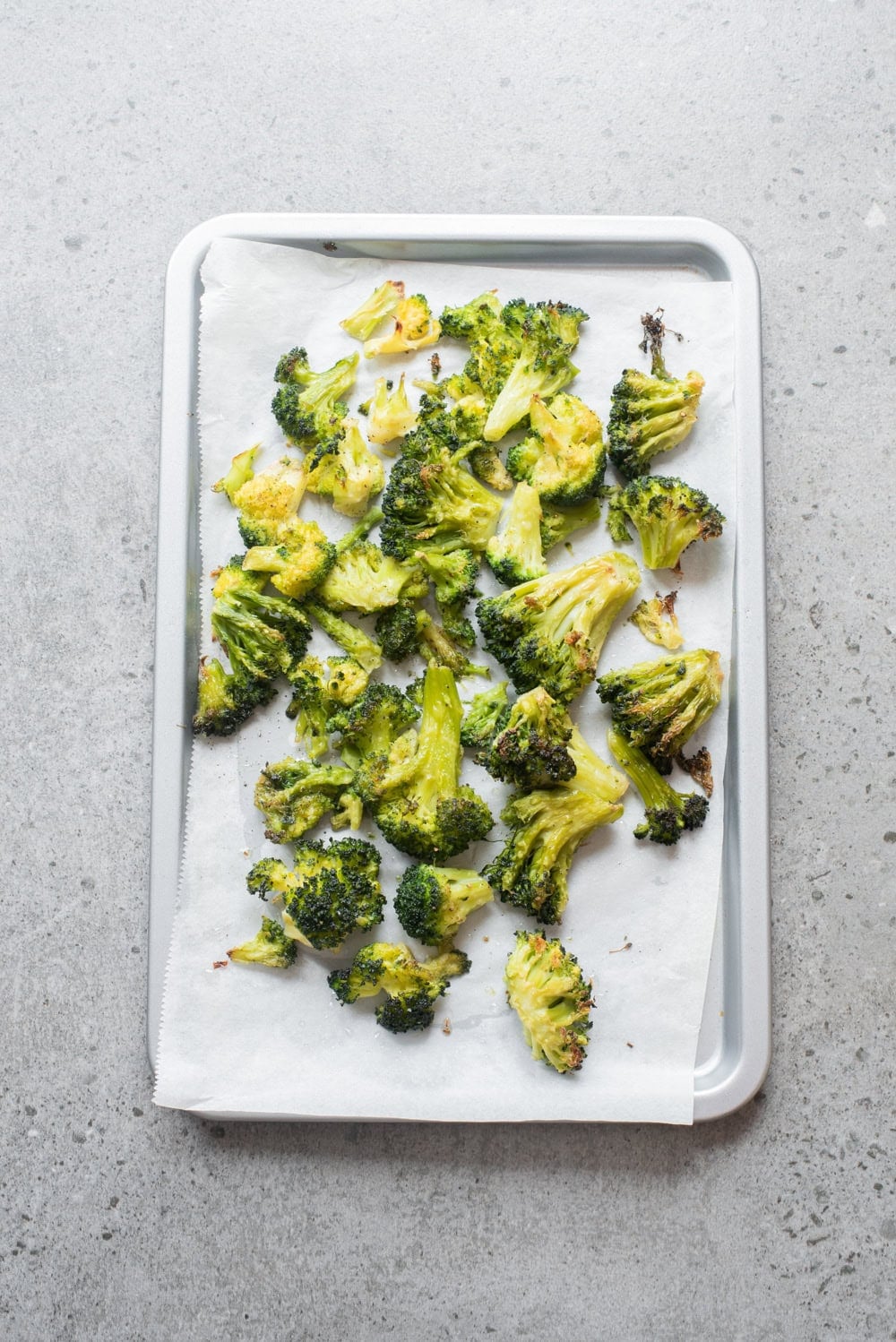 An overhead image of broccoli on a sheetpan.