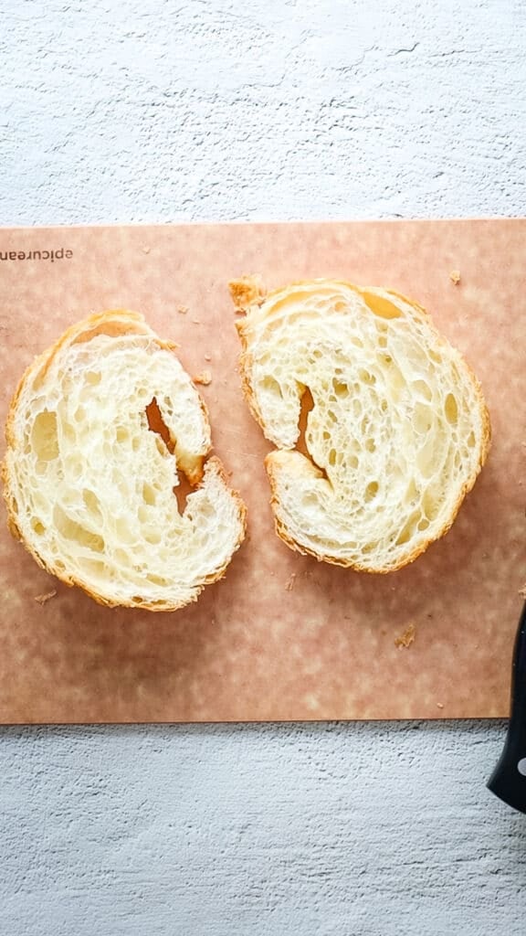 Overhead view of croissant halves on cutting board.